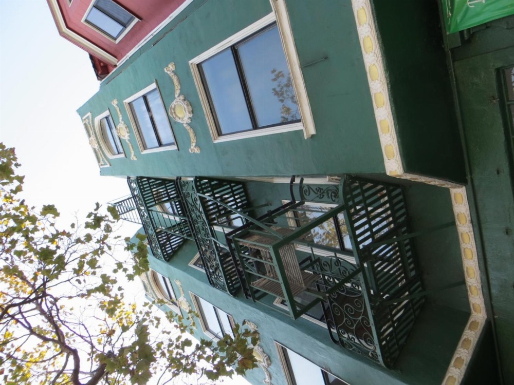 A green building with ornate details and balconies