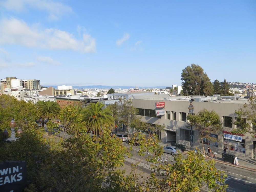 A city view with trees and buildings under a blue sky